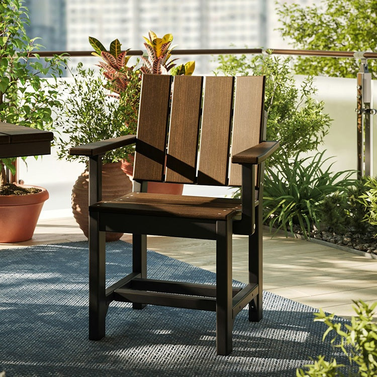 This is a lifestyle image showing the Brazilian Walnut and Black colored Urban Arm Chair on an outdoor patio.