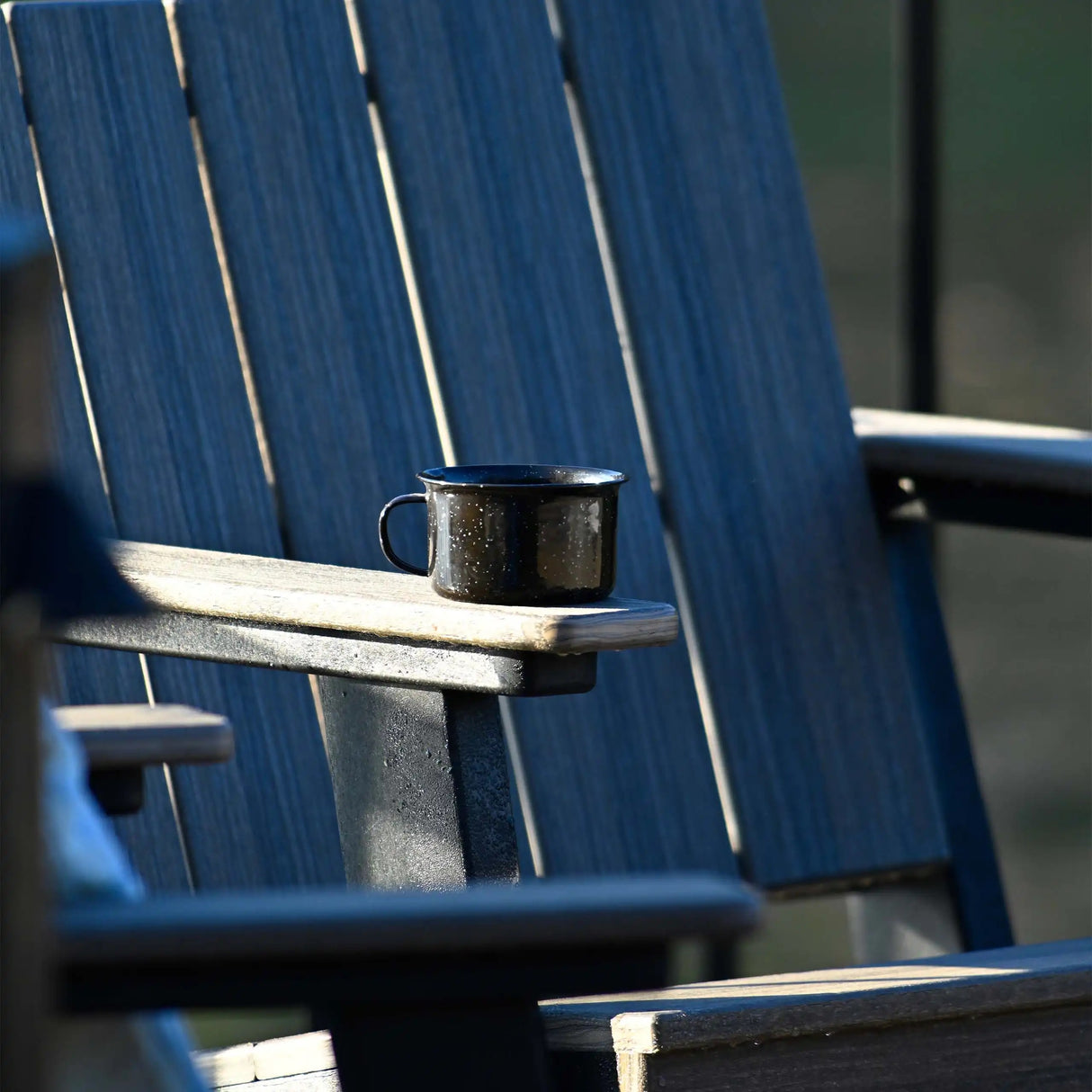 This is an up close view of the Blue and Black colored chat chair with a black mug on the armrest.