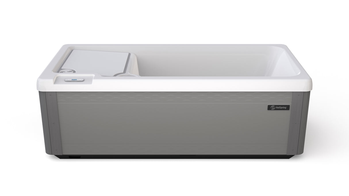 Long, rectangular tub designed for a cold plunge. The cabinet color is a tan-ish gray color and the inside is white. There's one seat.