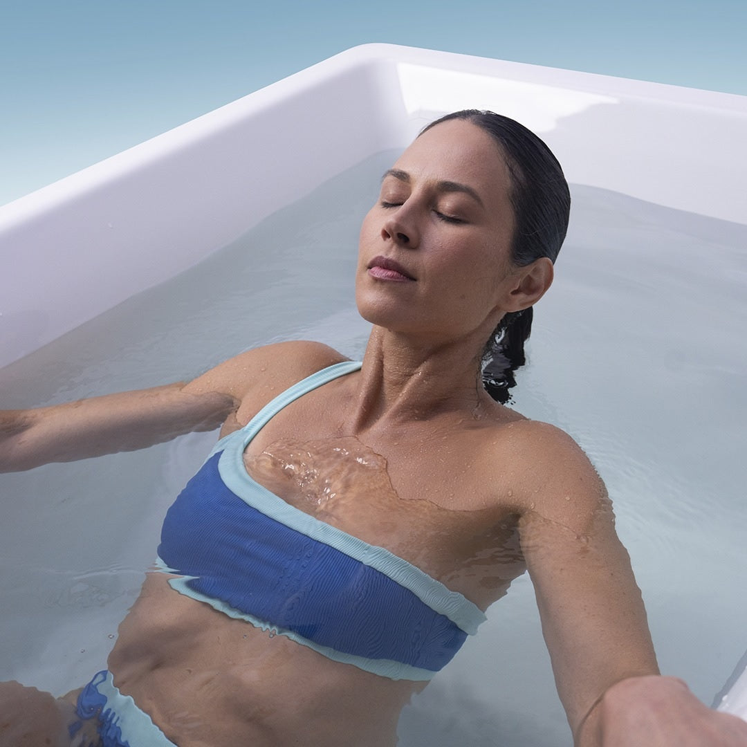 This image shows the woman lowering her entire body into the cold water.