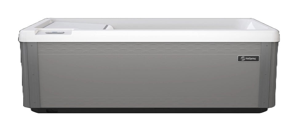 Long, rectangular tub designed for a cold plunge. The cabinet color is a tan-ish gray color and the inside is white. There's one seat. This is the view from the side.