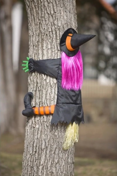 Decoration shaped like a witch who looks like she just crashed into a tree.