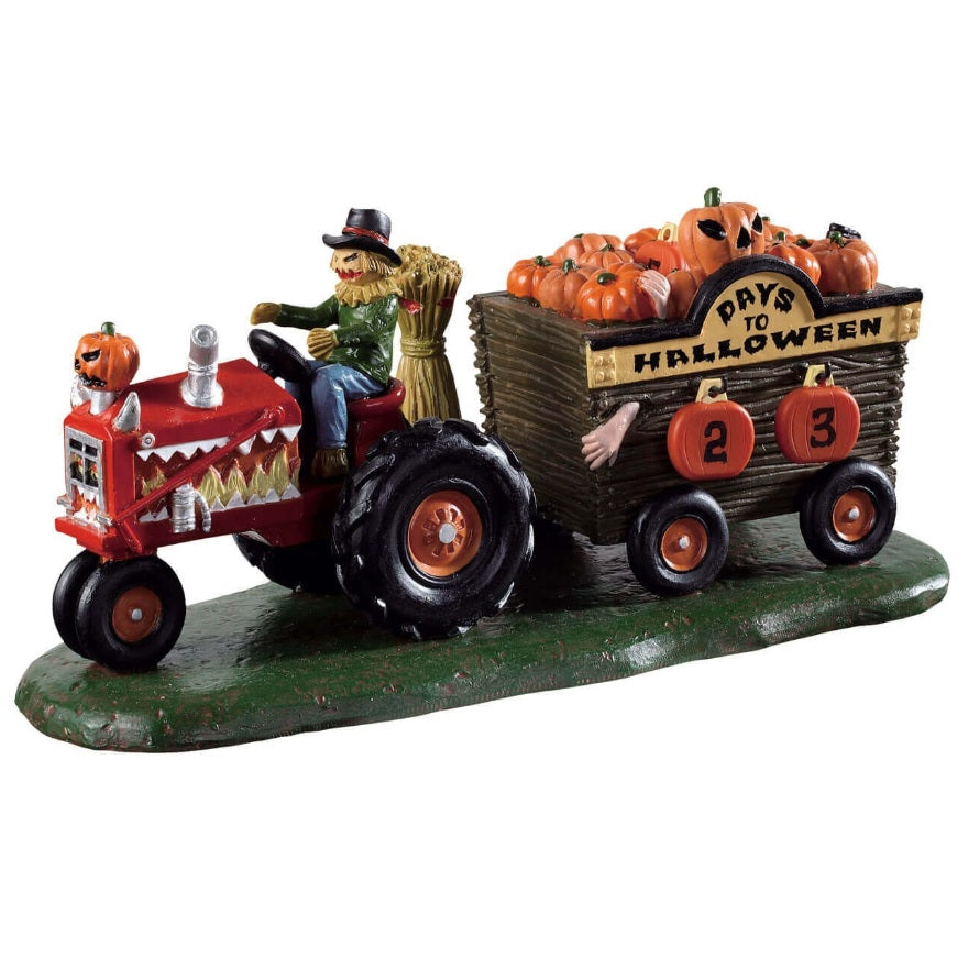 Polyresin village accent for a Lemax display. Designed to look like a scarecrow driving a red tractor with cart attached to it that's full of pumpkins. There's a sign on the side that reads DAYS TO HALLOWEEN and you can change the number.