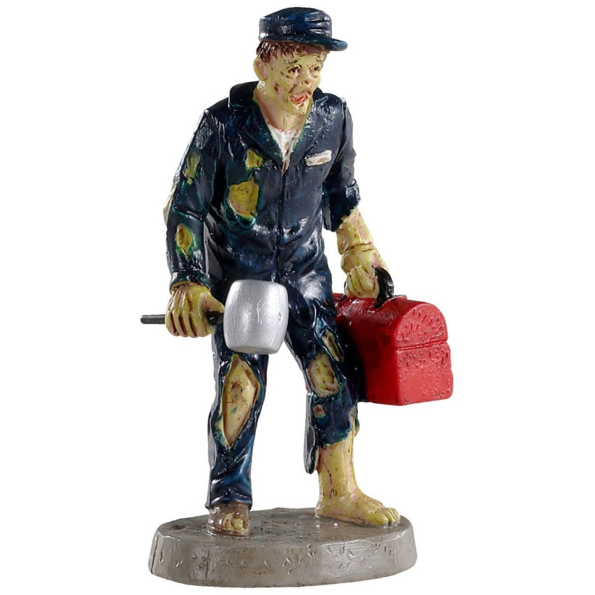 Polyresin figurine for a Lemax Spooky Town display. Designed to look like a monster mechanic. He's holding a hammer and a red tool box. He's wearing a blue cap and blue, torn up coveralls. He's barefoot.