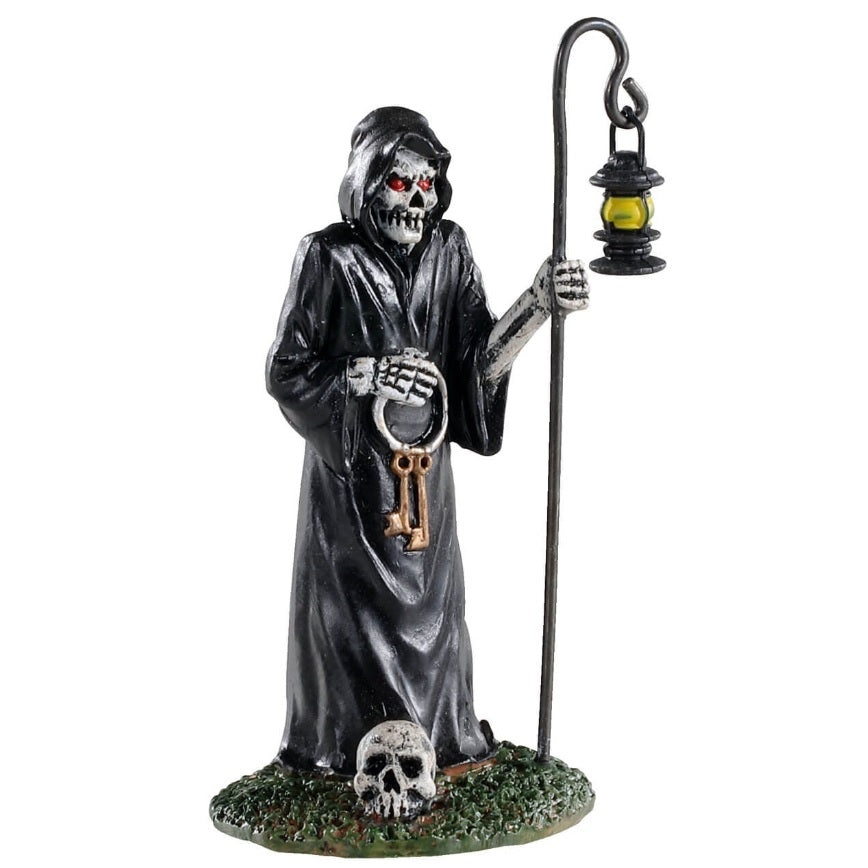 Polyresin figurine for Lemax Spooky Town display. Designed to look like the Grim Reaper. It's a skeleton wearing a big, black cloak and holding keys and a pole with a lantern on it. His eyes are red and he's standing on a patch of grass. There's a skull on the grass.