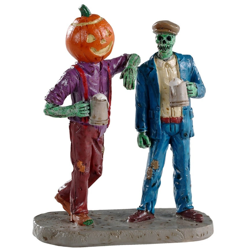 Polyresin figurine for a Lemax Spooky Town village display. Designed to look like two spooky buddies standing around drinking. A man with a pumpkin for a head is wearing a purple shirt with red overalls and his arms are green. He's resting his arm on the shoulder of the second man who is a green skeleton wearing a blue suit and a brown caddy cap. They're both holding mugs.
