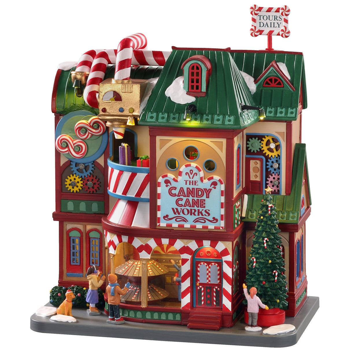 Polyresin building for a Lemax display. Designed to look like a very colorful candy store. The pipes on top are designed to look like candy canes. There are colorful gears visible and you can see presents rotating inside. There are kids looking at the candy and a girl admiring a decorated Christmas tree. There's also a dog wearing a Santa hat on the sidewalk.