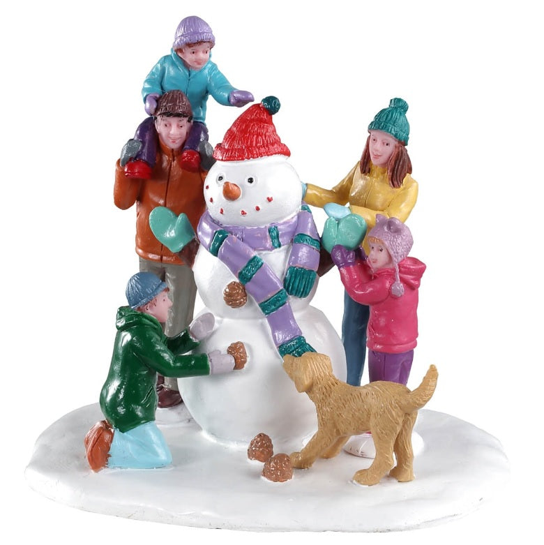 Polyresin figurine for a Lemax Village tabletop display. Designed to look like a family of five putting the finishing touches on a snowman while the family dog tries to steal the snowman's scarf