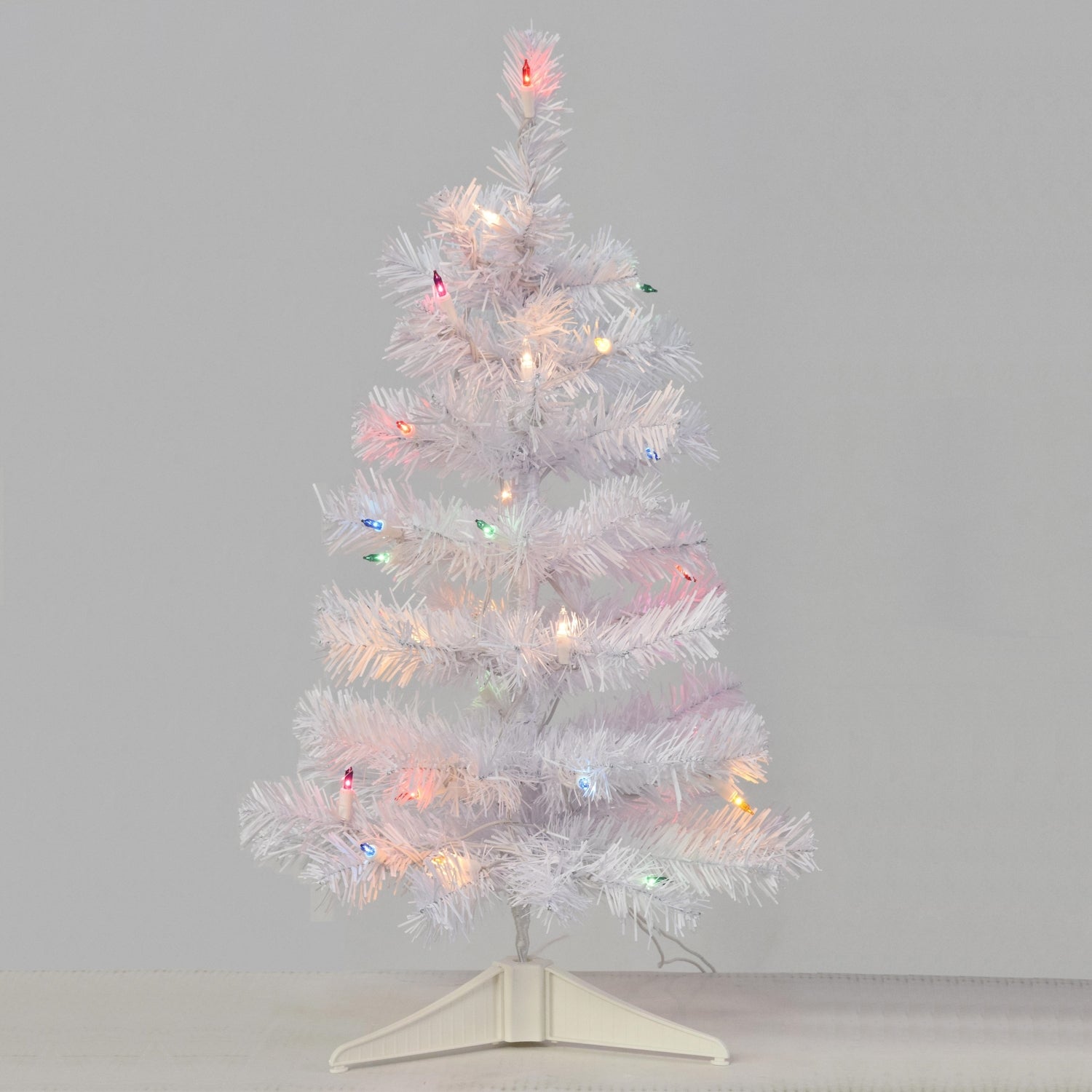Small white tree pre-lit with multi-colored lights.
