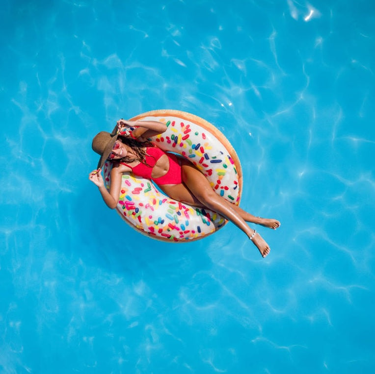 Inflatable inner tube designed to look like a donut with frosting and multi-colored sprinkles.