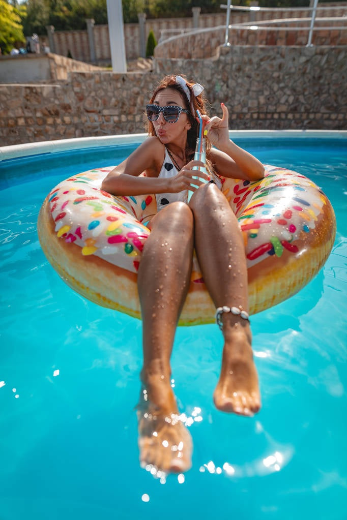 Inflatable inner tube designed to look like a donut with frosting and multi-colored sprinkles.