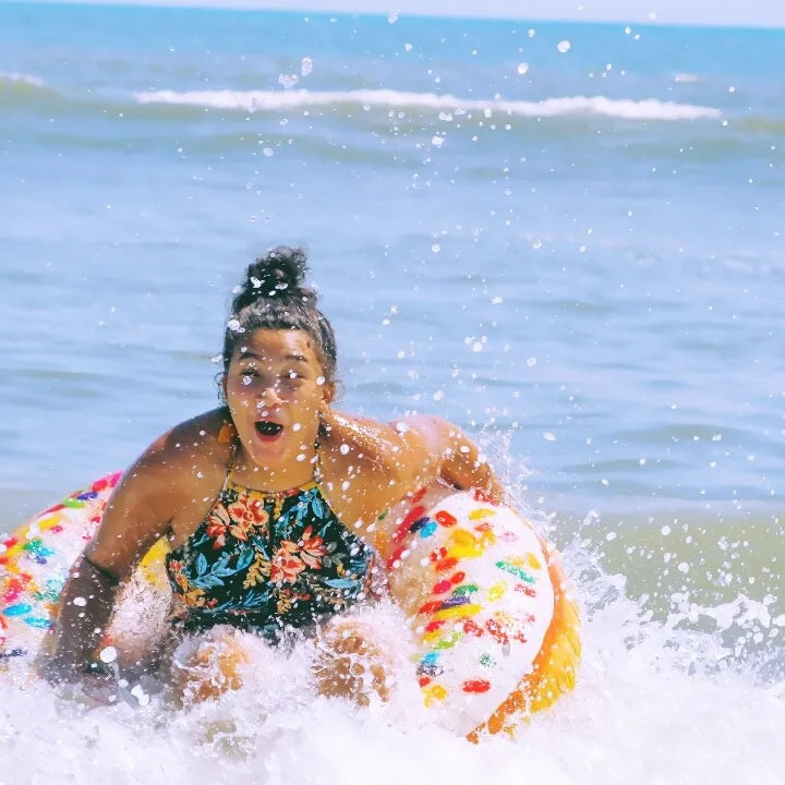 Inflatable inner tube designed to look like a donut with frosting and multi-colored sprinkles.