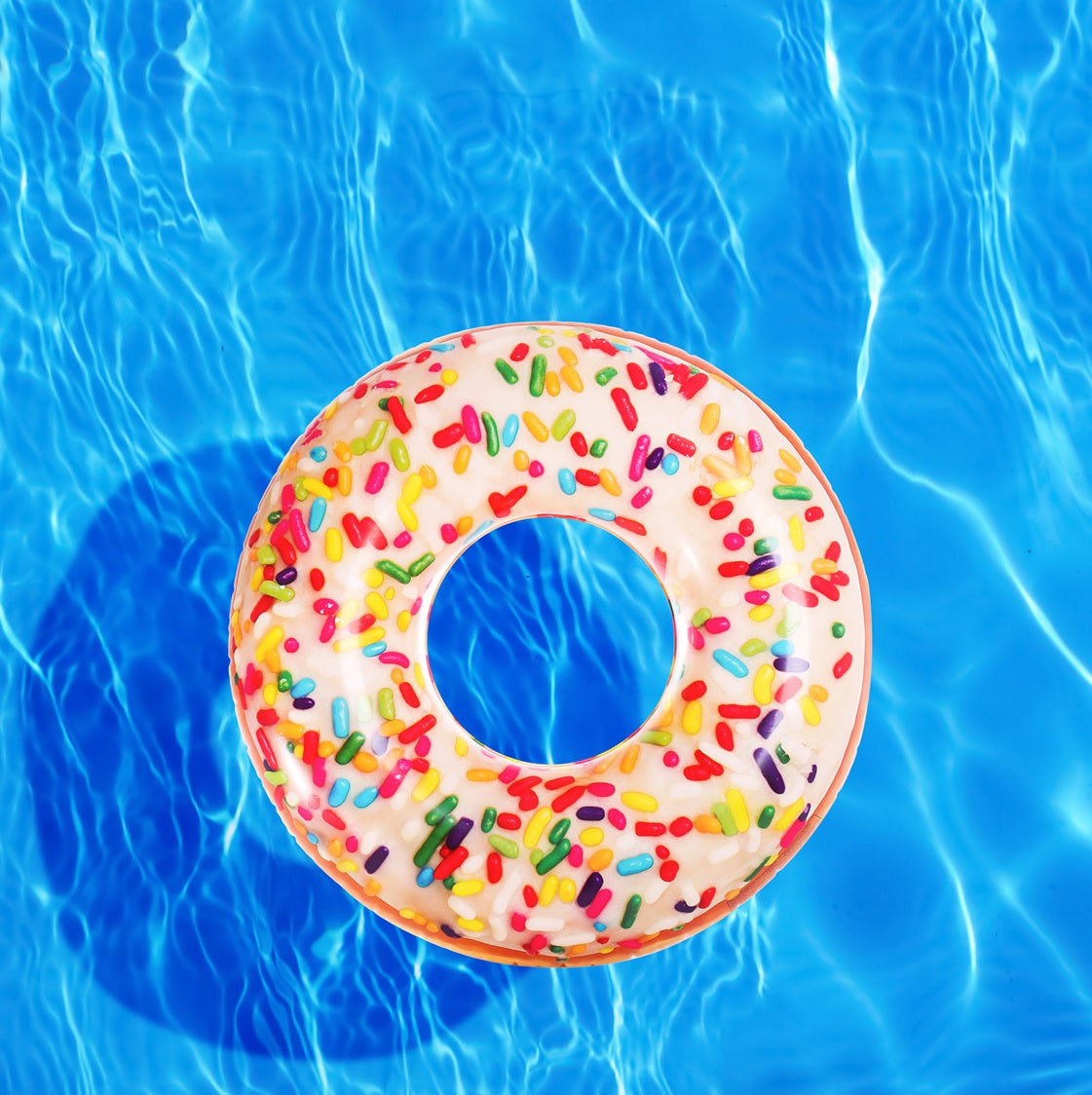 Inflatable inner tube designed to look like a donut with frosting and multi-colored sprinkles.