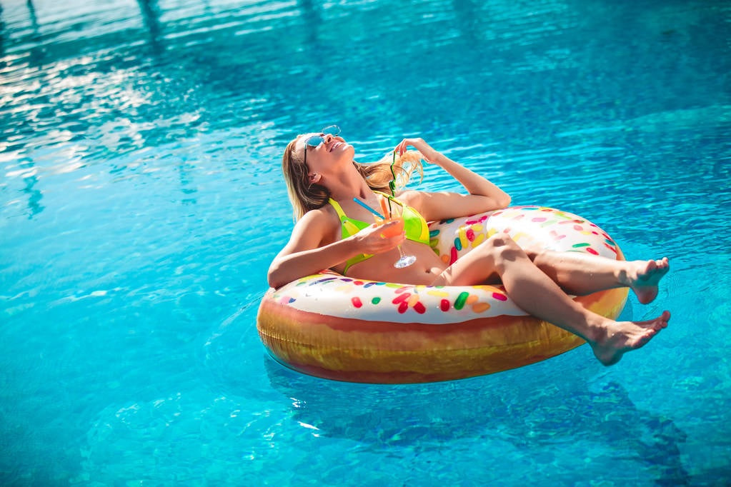 Inflatable inner tube designed to look like a donut with frosting and multi-colored sprinkles.