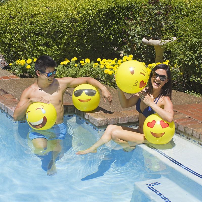 Yellow beach balls designed to look like different emojis.