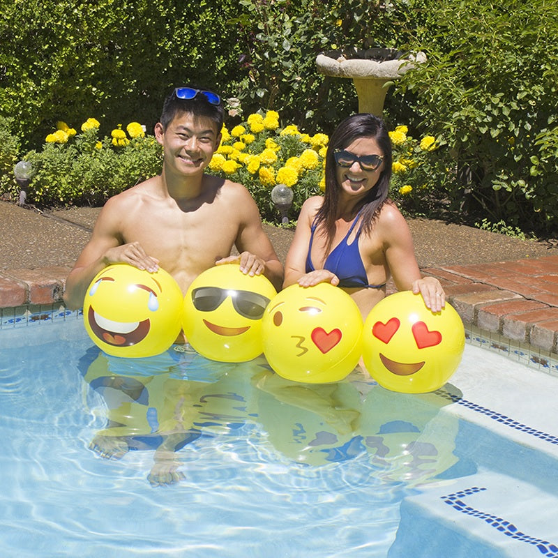 Yellow beach balls designed to look like different emojis.
