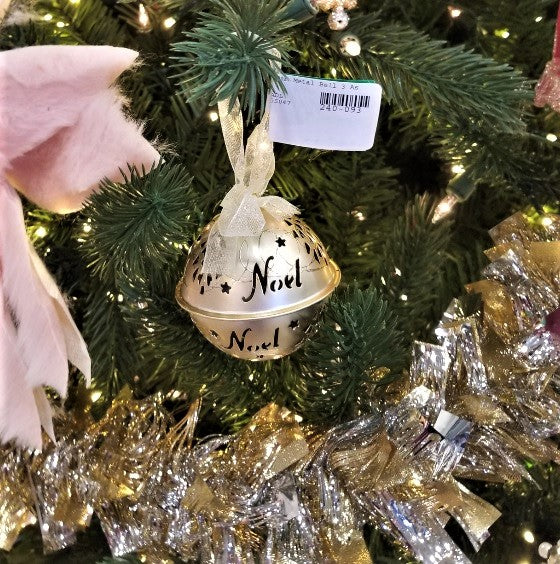 Gold bell ornament. There are star cutouts and a cutout that reads "NOEL."
