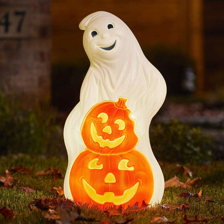 A blow mold Halloween decoration designed to look like a smiling ghost with two carved jack-o-lanterns stacked in front of it.