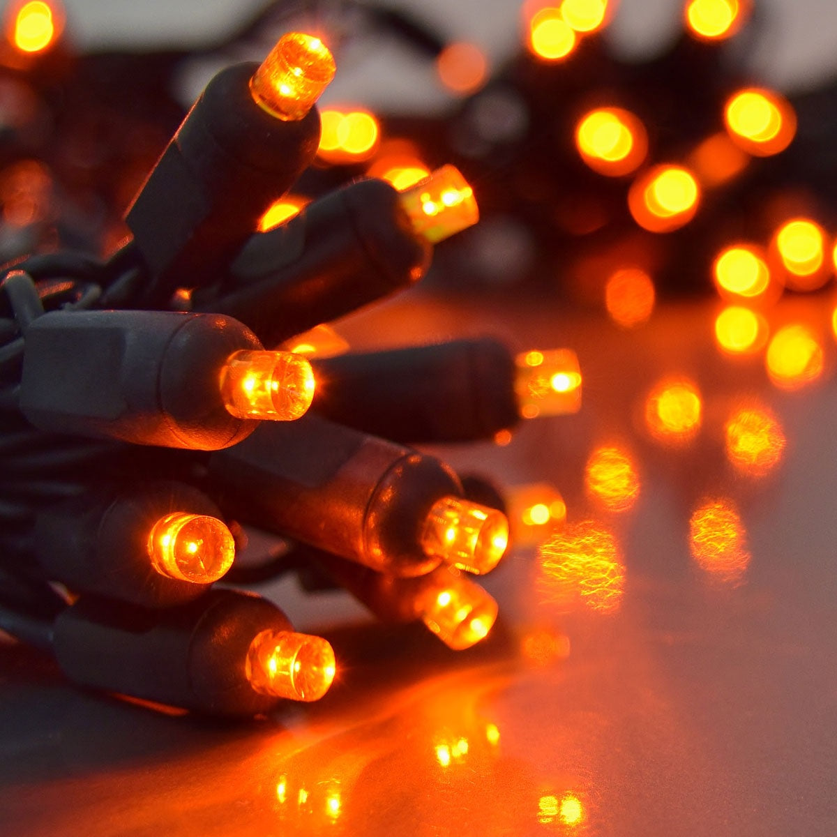 Battery operated orange lights on a black wire.
