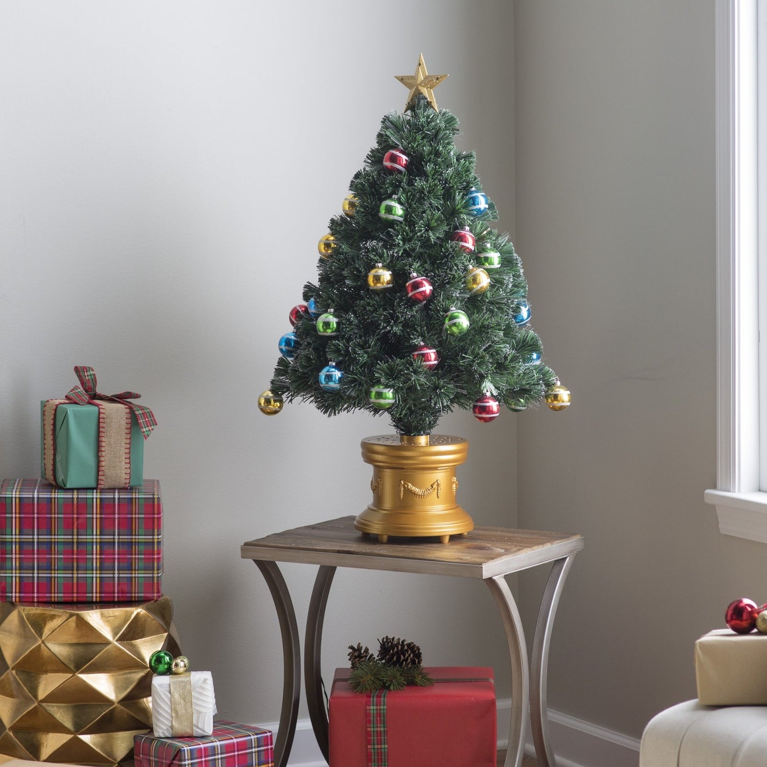 3 ft. fiber optic tree with multi-colored, glittered ball ornaments, a gold base and a star on top.