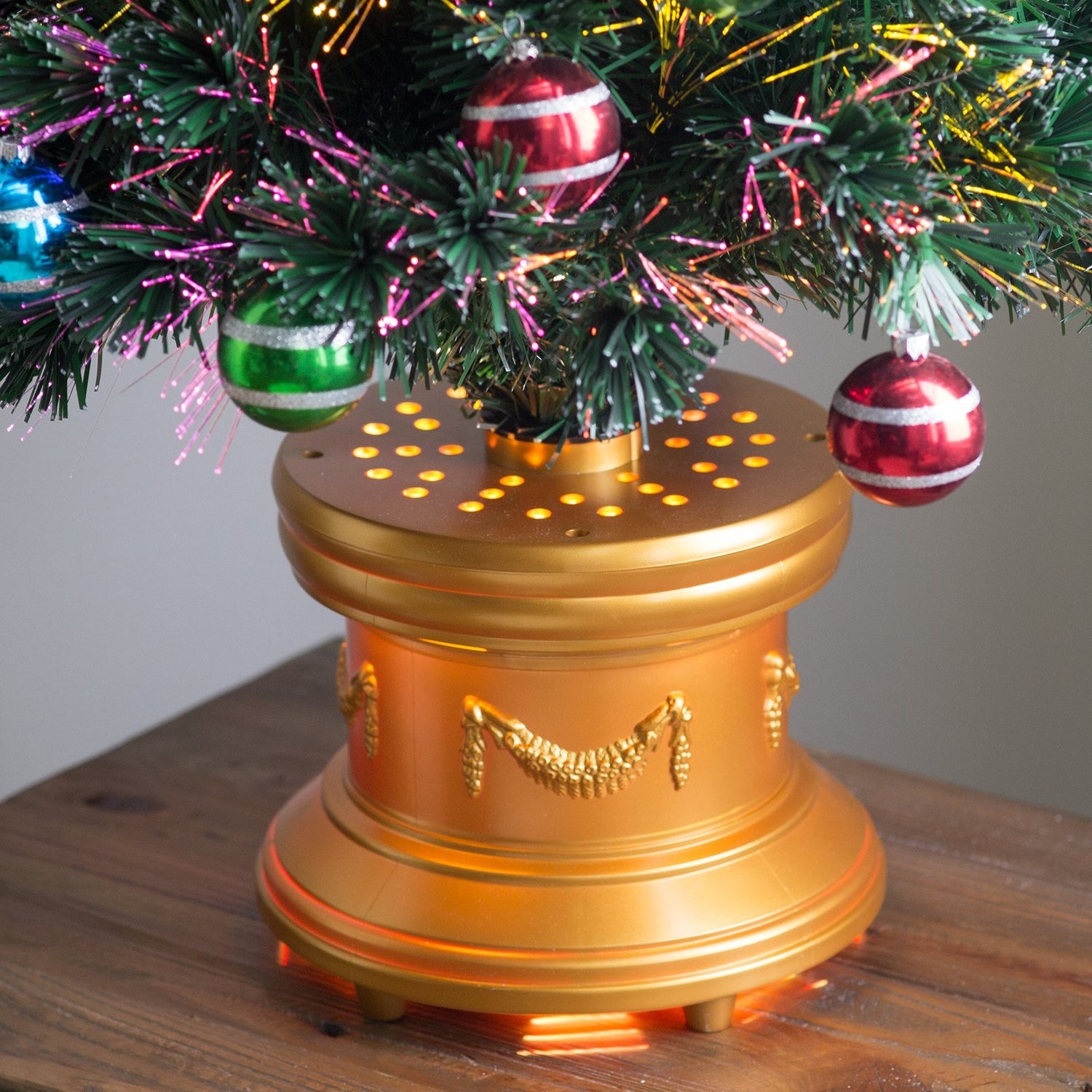 3 ft. fiber optic tree with multi-colored, glittered ball ornaments, a gold base and a star on top.