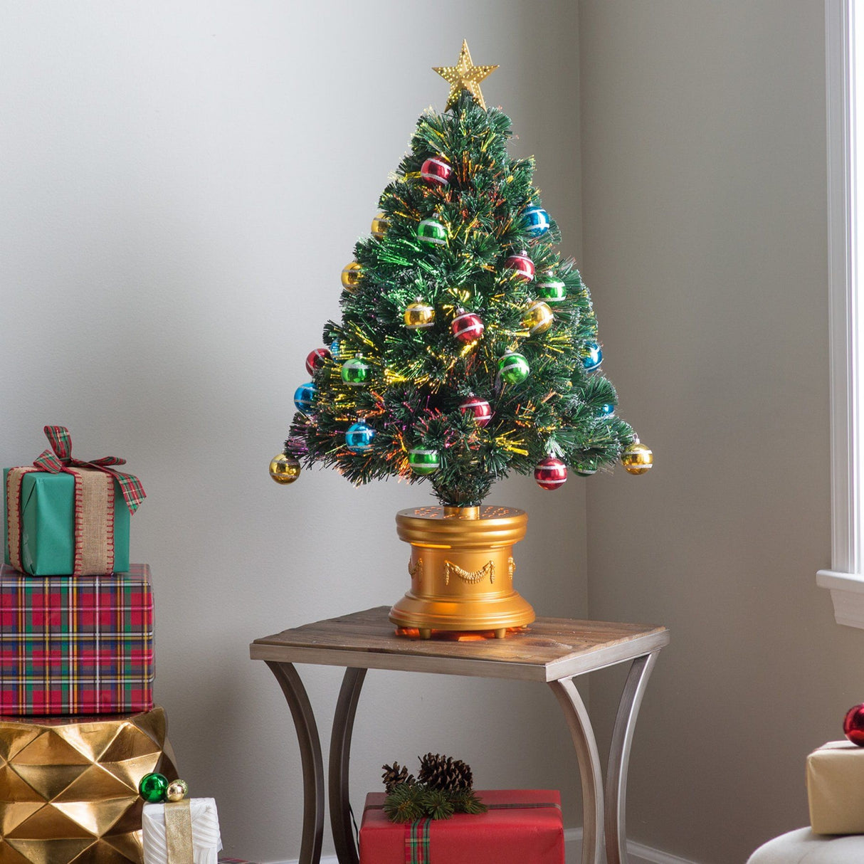 3 ft. fiber optic tree with multi-colored, glittered ball ornaments, a gold base and a star on top.