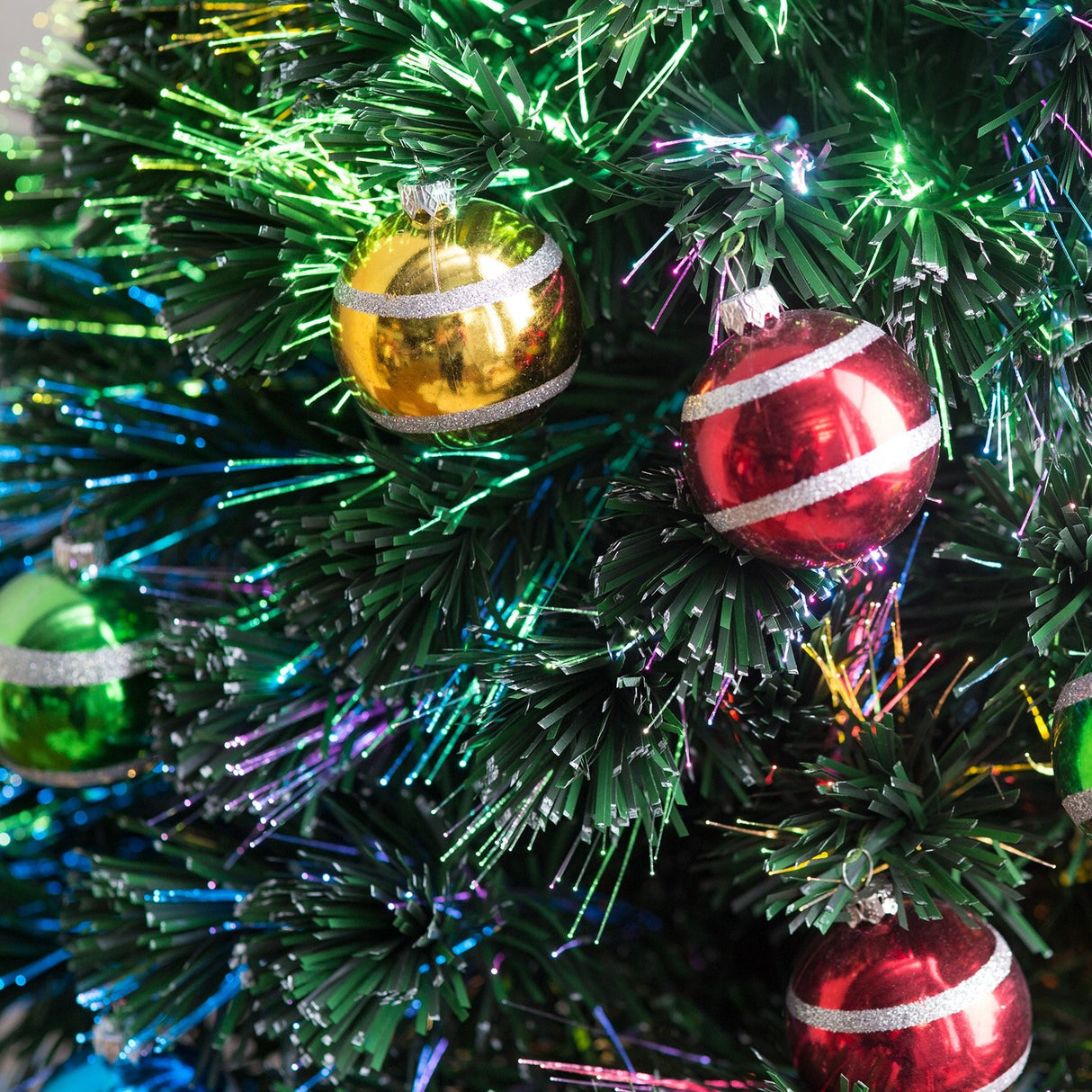 4 ft. fiber optic tree with multi-colored, glittered ball ornaments and a gold base.