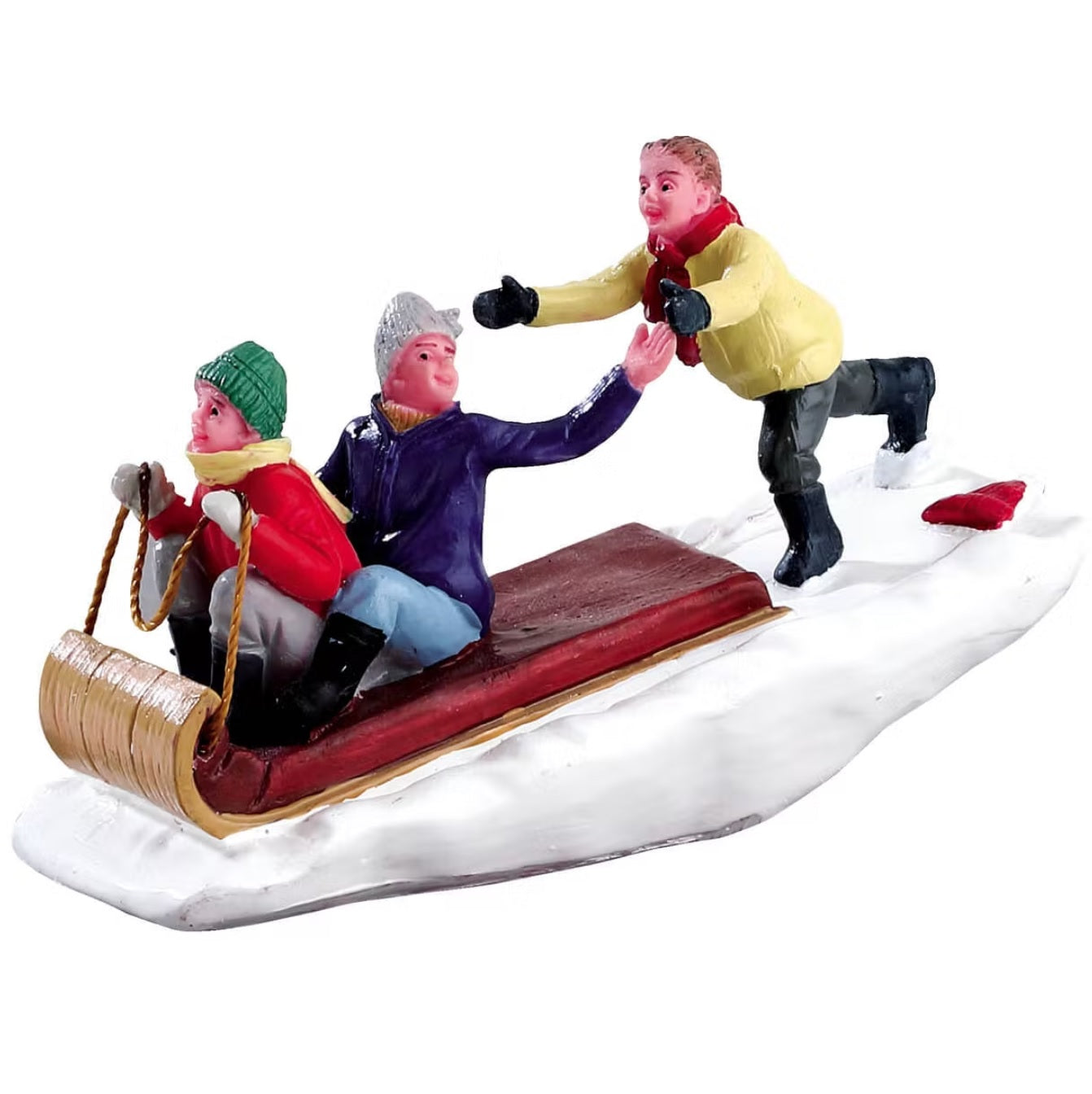Polyresin figurine for a Lemax display. Designed to look like a young boy chasing after his two friends in a toboggan. They're all wearing winter clothes and the ground is covered in snow.