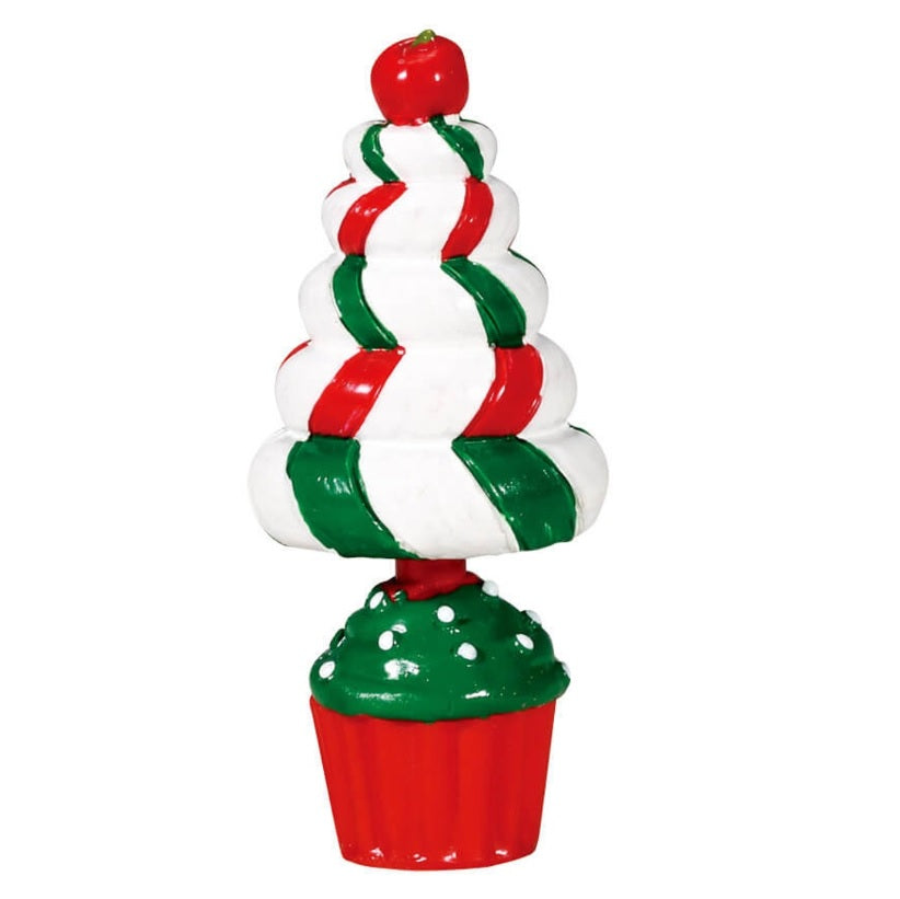 A Lemax village accessory that's supposed to act like a small, fake tree made out of desserts. It looks like a green and red cupcake with a large whipped cream shaped like the top part of the tree. There's a cherry on top.