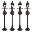 Set of 4 Lemax village lampposts. Each is decorated with a Christmas wreath.