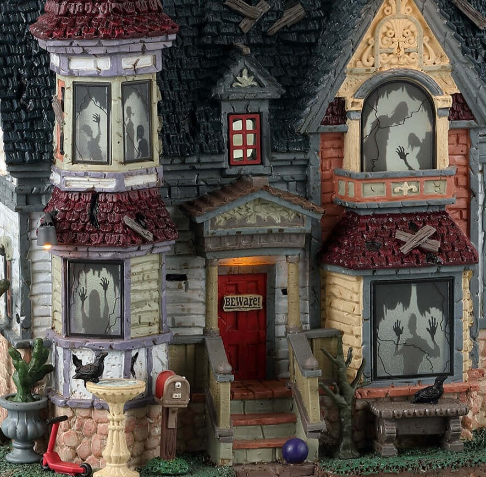 Resin lighted building for a Lemax display. Designed to look like a run down, Victorian-era style mansion. There are ghost shadows in every window and crows all over.