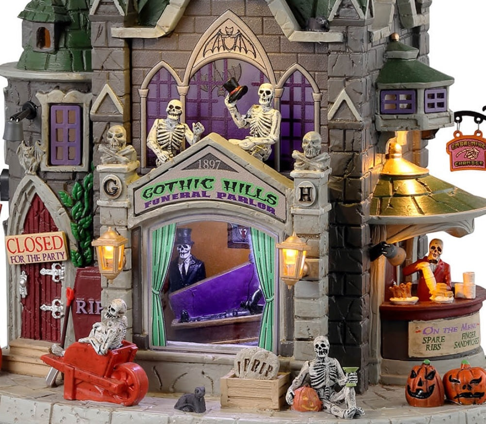 Resin lighted building for a Lemax display. Designed to look like a gothic castle. There are skeletons and skull accents, as well as gargoyles, pumpkins and rats. Inside the window you can see a skeleton testing out a coffin. Over to the right, there's a bar with a skeleton ready to serve you.