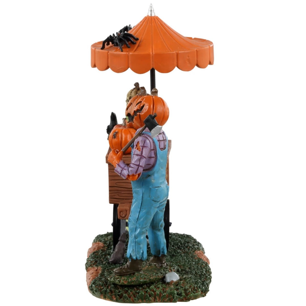 Resin table accent for a Lemax display. Designed to look like a scarecrow with a pumpkin head standing in front of a cart full of carved pumpkins. There's an orange umbrella above the cart with spiders on top. There's a sign on the ground that reads "Fried crow wings, moldy pumpkin bread and rancid pumpkin seeds."