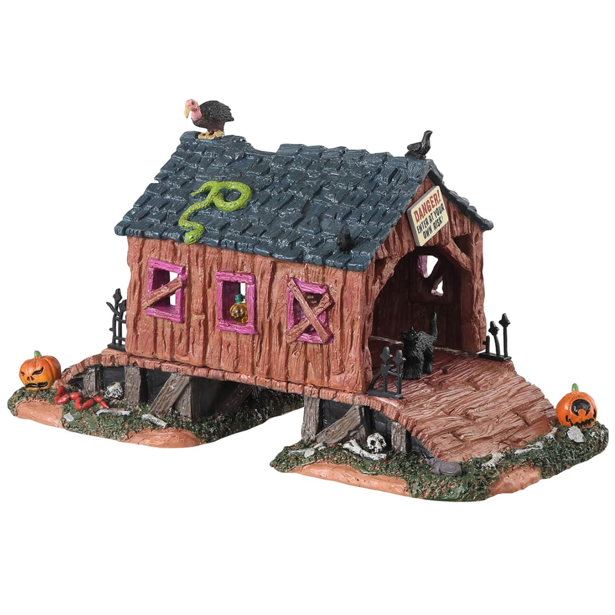Resin village table accent for a Lemax display. Designed to look like a rotted out, covered bridge. There's a green snake and a vulture on the roof. There's a black cat and a bunch of pumpkins and bones on the ground.