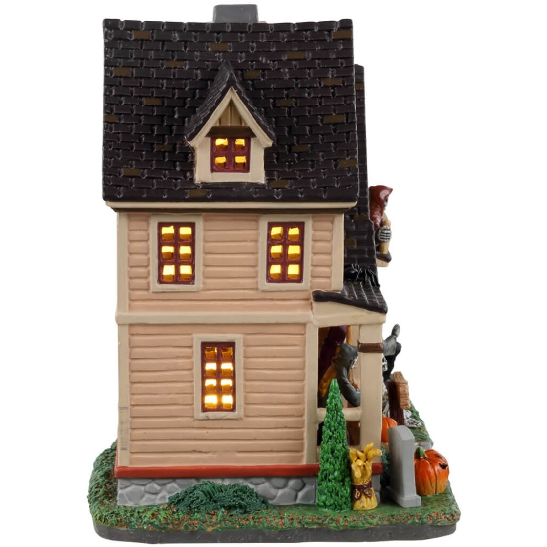Porcelain lighted building for a Lemax display. Designed to look like a large house with many lit up windows. There are skeletons on the porch, on the front lawn and in the garage. There are also black cats and pumpkins and a little tombstone that reads "RIP."