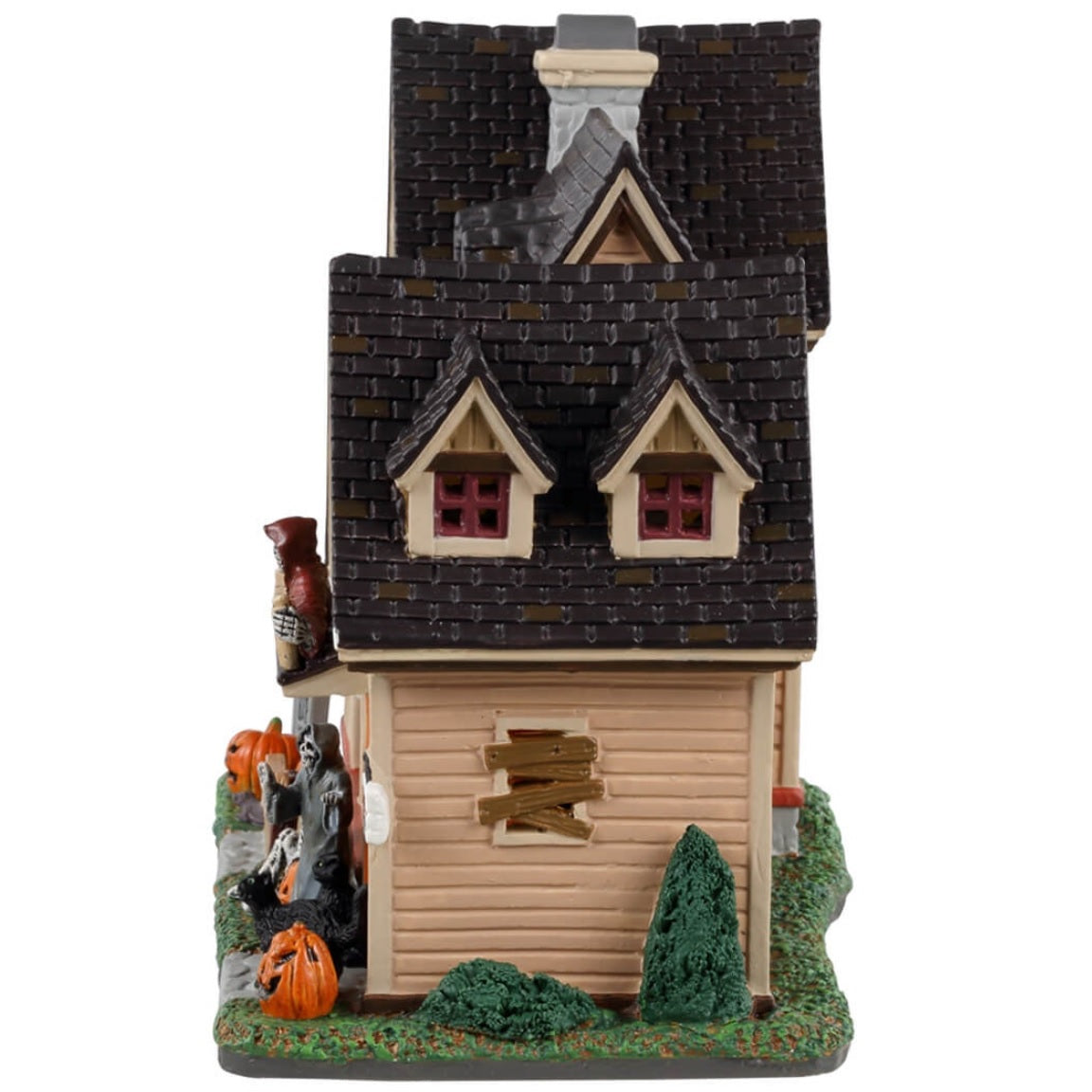 Porcelain lighted building for a Lemax display. Designed to look like a large house with many lit up windows. There are skeletons on the porch, on the front lawn and in the garage. There are also black cats and pumpkins and a little tombstone that reads "RIP."