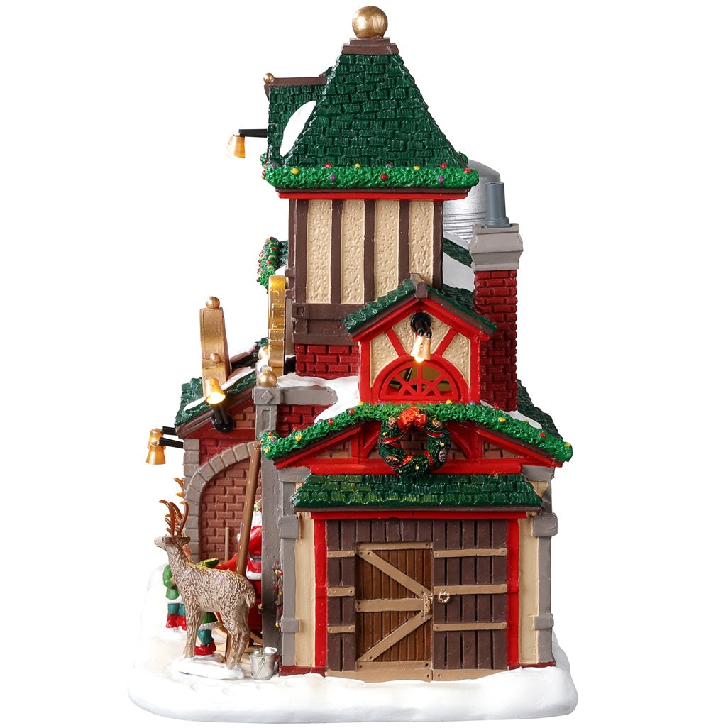 Resin lighted building for a Lemax display. Designed to look like Santa's Reindeer Stables. There are reindeer eating and elves helping Santa Claus get his sleigh ready.