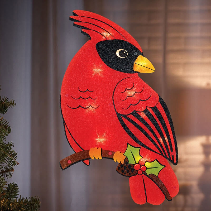 LED holiday decoration shaped like a cardinal standing on a branch with holly leaves, berries and a pine cone.