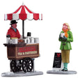 Polyresin figurines for a Lemax Village tabletop display. Designed to look like a coffee vendor chatting with a woman holding a cup. The cart reads "Hot Coffee, Tea & Pastries." There's a red and white umbrella sticking out of the cart.