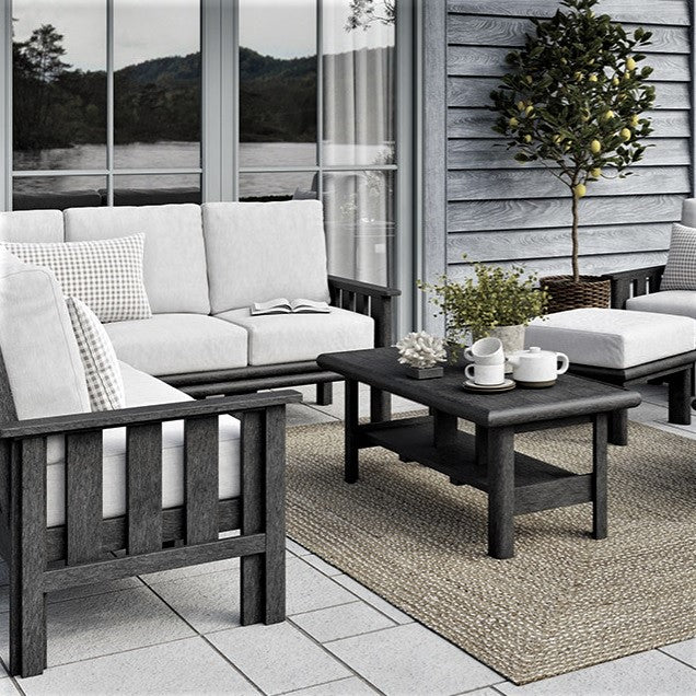 An outdoor patio furniture set on a porch next to a house