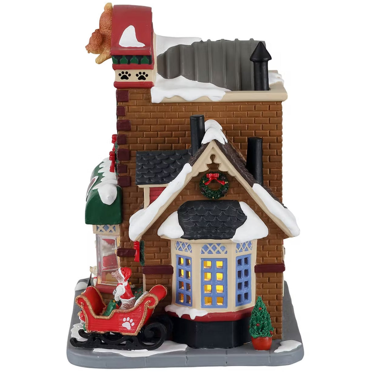 A porcelain lighted building for a Lemax display. Designed to look like a stone motel. There's a fake dog on the roof and a sign that reads "Wags Motel & Doggy Daycare." There's snow on the roof and on the ground. The building is decorated for Christmas and Santa is taking pictures with a dog in the front window. There are dogs wearing Santa hats and a dog in a red sleigh off to the side.