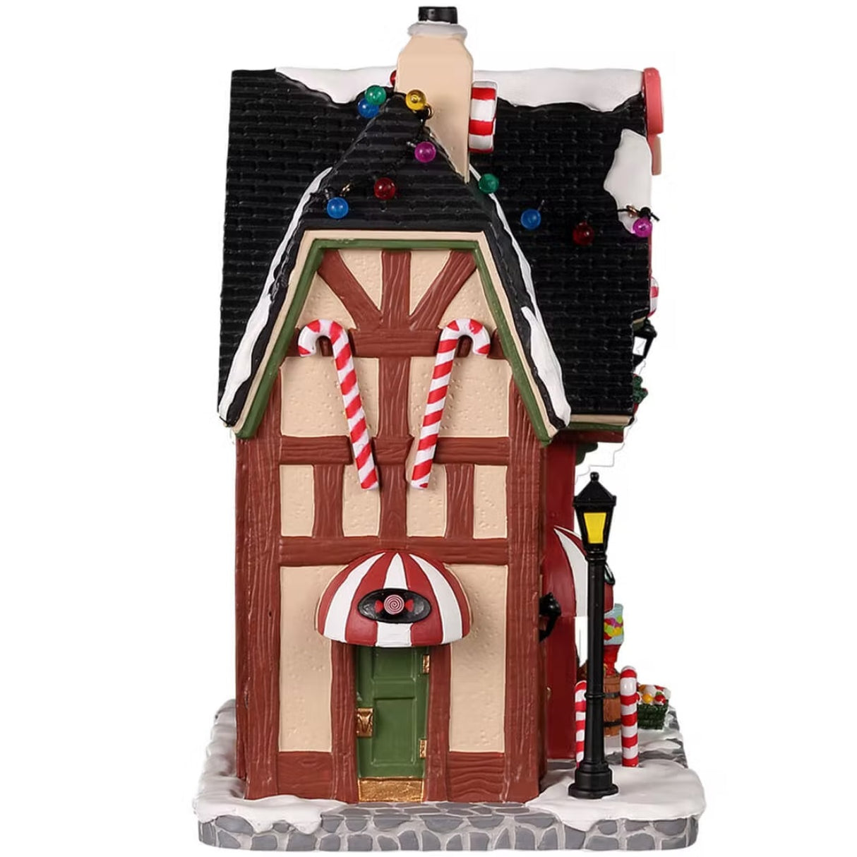 Porcelain lighted building for a Lemax display. Designed to look like a candy shop. There's snow on the roof and the sidewalk. Inside the window, you can see a bunch of candy on display. In front of the shop, there are peppermint candy canes, baskets of candy and a bubblegum machine.