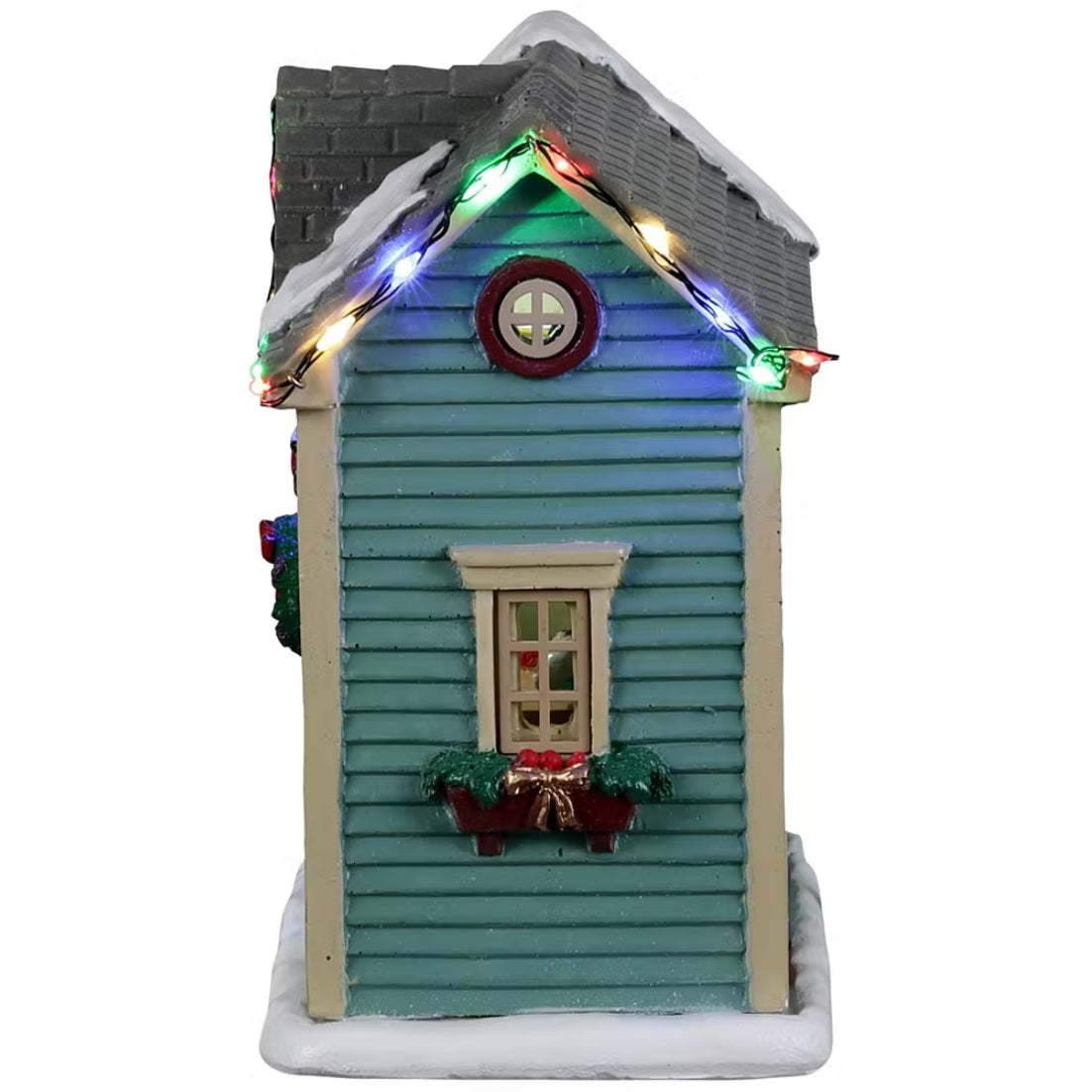 Resin village accent for a Lemax display. Designed to look like a turquoise shed with red barn doors and a gray roof. There's snow on the roof and multi-colored lights. There are wreaths on the doors and candy canes painted on the side. Inside the shed, you can see a woman decorating a wreath.