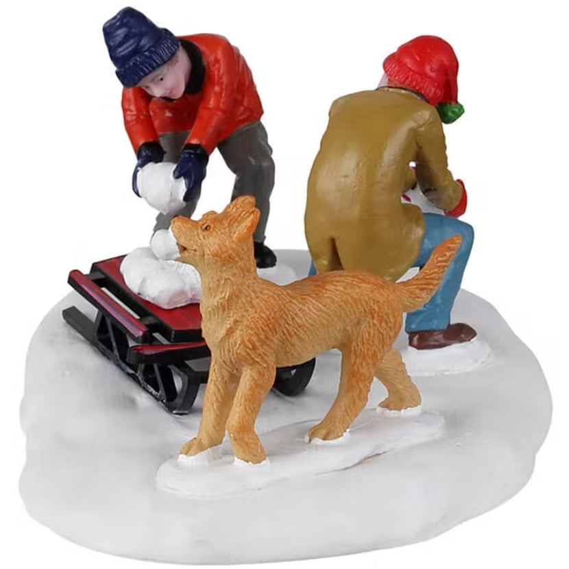 Resin village accent for a Lemax display. Designed to look like two boys and a dog collecting snowballs and putting them on a red sled.