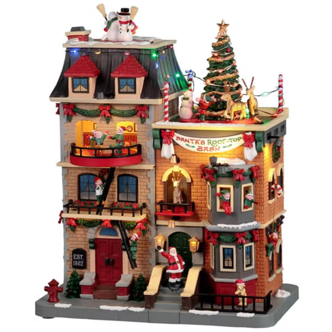 Resin lighted building for a Lemax display. Designed to look like a large, brick apartment complex that's decorated for Christmas. There are elves hanging out of the windows and standing on balconies. There are snowmen, reindeer and a decorated Christmas tree on the roof. Santa is waving from the stairs and there's a dog wearing a Santa hat on the sidewalk.