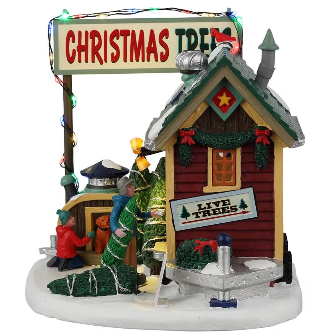 Resin lighted building for a Lemax display. Designed to look like a small shack. There are solar panels and snow on the roof. The door is open and there's a person inside selling Christmas trees and wreaths. There's a young child and a dog checking out some of the trees off to the side.