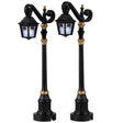 Plastic village accessories for a Lemax display. Designed to look like regal lampposts. They're shiny black with gold accents. The glass on the light has a skeleton wearing a black top hat.