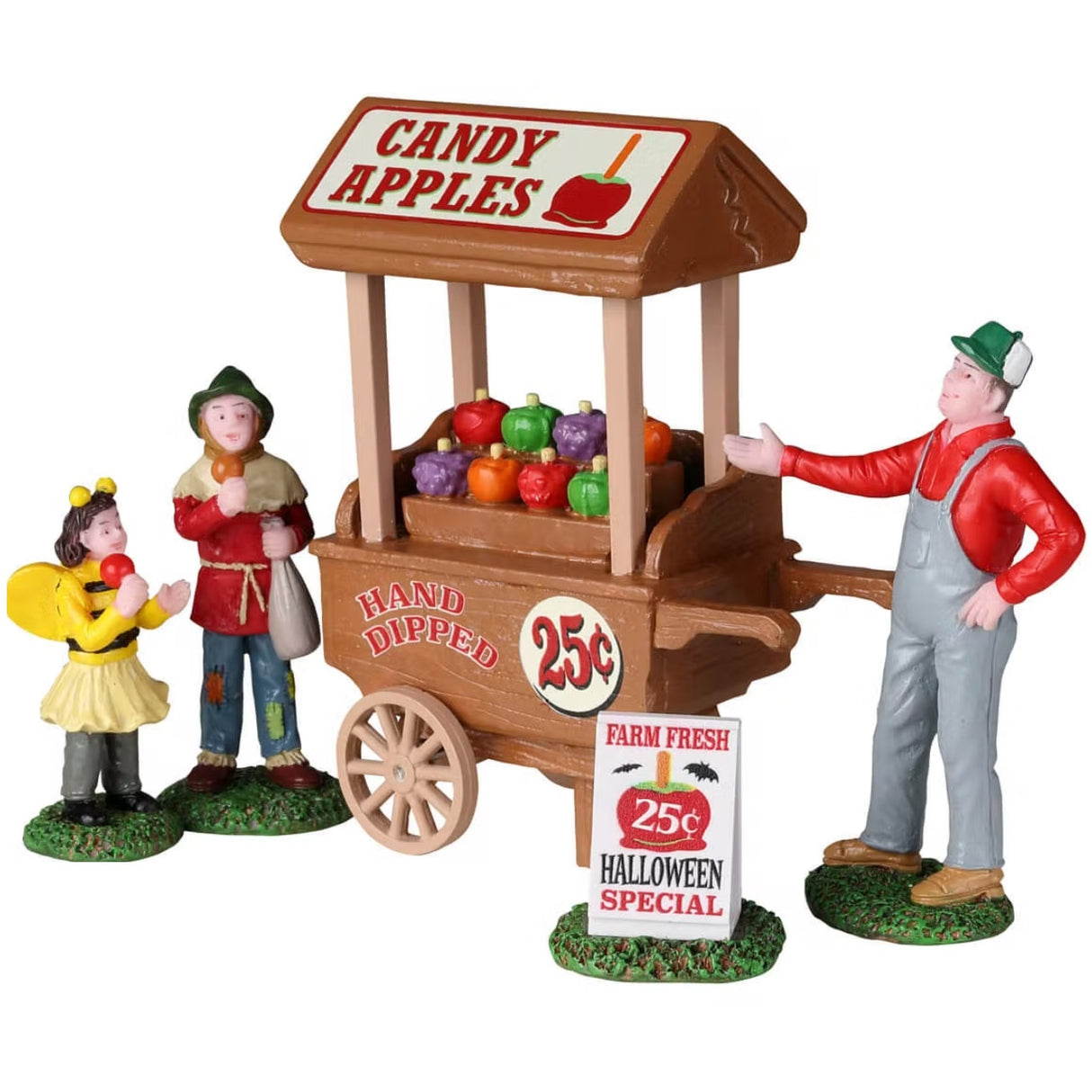 Polyresin figurines for a Lemax display. Designed to look like a candy apple vendor handing apples to two kids dressed in costumes. The apple cart reads "CANDY APPLES. HAND DIPPED. 25 CENTS." There's a sign on the ground that reads "Farm Fresh. 25 cents. Halloween Special." The little girl is dressed like a bumblebee and the boy is dressed like a scarecrow.