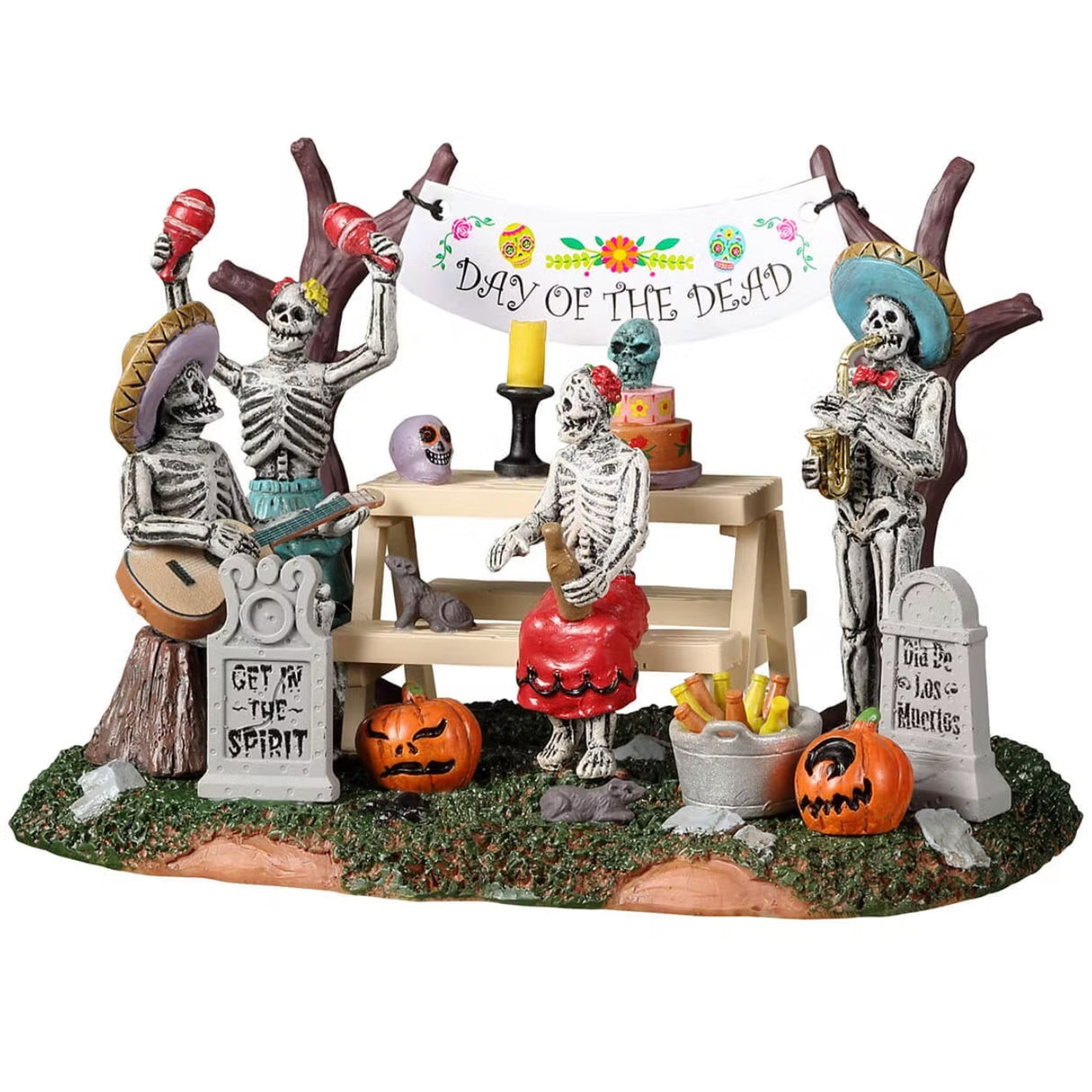 Resin village accent for a Spooky Town Lemax display. Designed to look like four skeletons enjoying a Day of the Dead celebration. There are tombstones, carved pumpkins and a banner hanging from the trees. There's a picnic table with a skull, a candle, a decorated cake and a rat on it.