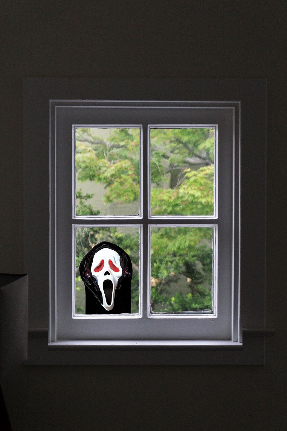 Decoration designed to be hung in your window or on a glass door. Looks like Ghost Face is peeping into your home, or peering out.